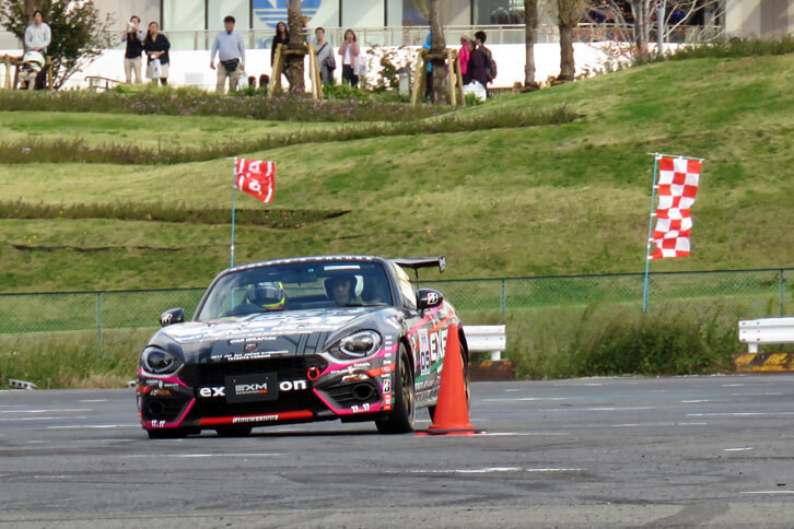 パイロンギリギリを攻める山野哲也選手の「アバルト124スパイダー」。前輪とパイロンとの距離にご注目。