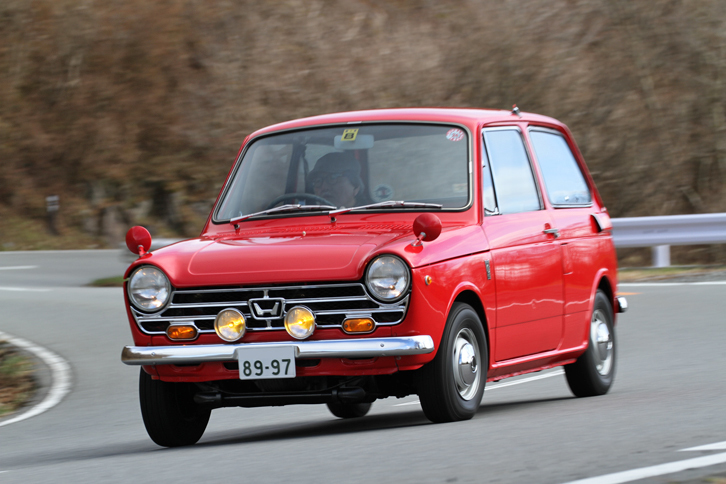 菊島氏が長年愛用している「N360S」（ボディー同色の専用フェンダーミラーや専用ホイールにフォグランプ、室内にはタコメーターや3本スポークのステアリングホイールなどを備え、スポーティーに装った1968年2月発売の「Sタイプ」）に、箱根で試乗する吉田氏。2012年に「ホンダN-ONE」がデビューした際に、『CAR GRAPHIC』誌の企画で新旧Nのインプレッションを行った際のショット。