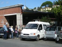 イタリア国鉄シエナ駅の脇に、出発を待つウクライナ行きバンが止まっているのは、ここ10年来よく見られる光景だ。そのはしりであった2010年の撮影。解説は本文で。