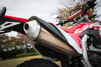 「CRF450L」を排出ガス規制に適合させるべく、新たに開発されたマフラー。左右2本出しの「CRF450R」に対して片側1本出しとなっているのが特徴で、燃調制御に用いるO2センサーが装備されるほか、キャタライザーが内蔵されている。