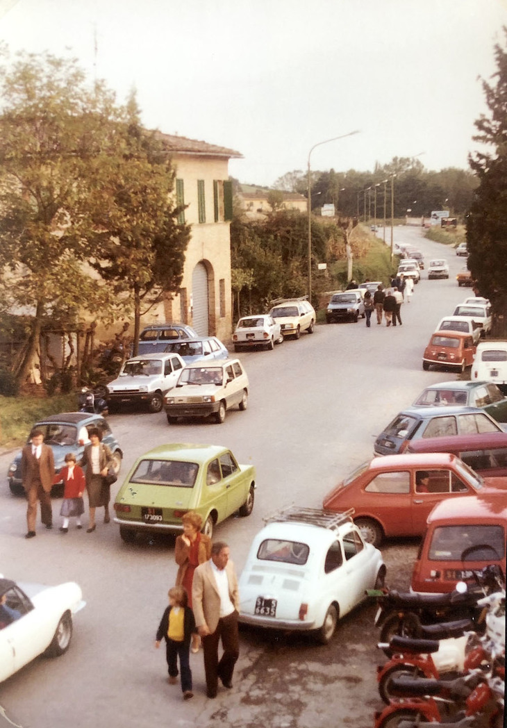 展示写真から。1980年代、店舗周辺のにぎわいを記録したスナップ。道を横切る家族の服装からは、クルマの発表会に行くのが週末の家族イベントだった時代がしのばれる。