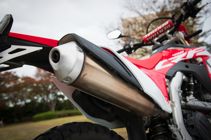 「CRF450L」を排出ガス規制に適合させるべく、新たに開発されたマフラー。左右2本出しの「CRF450R」に対して片側1本出しとなっているのが特徴で、燃調制御に用いるO2センサーが装備されるほか、キャタライザーが内蔵されている。