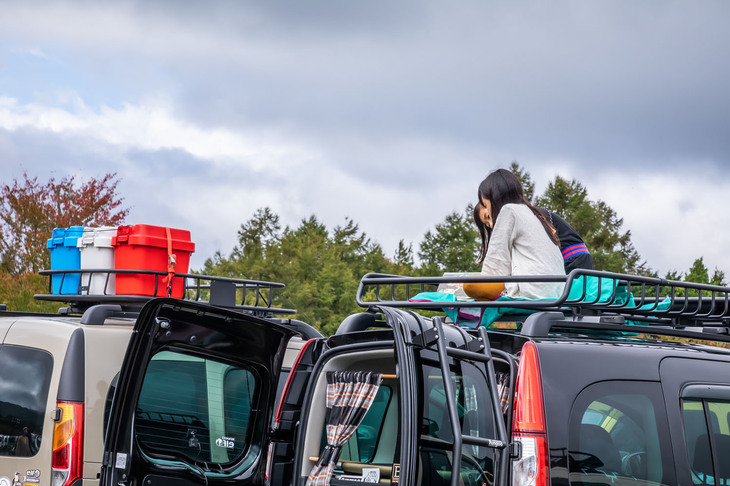 ルーフキャリアの上で絵本を見ながらくつろぐ子供たち。こうした自由な光景も「カングージャンボリー」ならでは。