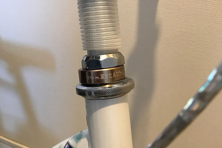 Mt富士ヒルクライムレースで90分を切るともらえる「“ブロンズ”フィニッシャーリング」。娘がレースに出場したのを記念して、ハンドルコラムに取り付けてあげた。