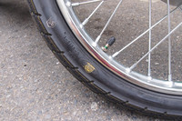 本モデルから中国製となった「スーパーカブ50」。タイヤのメーカーロゴの上に黄色い軽点マーク（タイヤの周上で最も軽い部分を示す）が乗ってしまっているおおらかさがすてきだ。