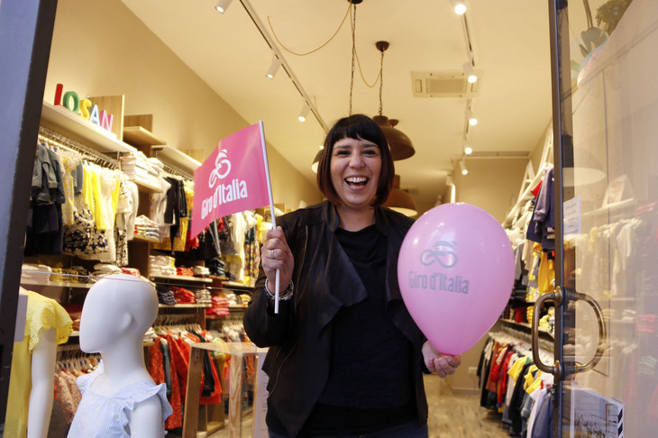 沿道の商店も、旗や風船をウィンドウに飾って雰囲気を盛り上げる。これは知人のマルタさんが営む子供服店にて。