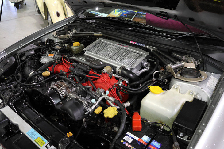 STI（スバル・テクニカル・インターナショナル）製の各種パーツで武装されたエンジンルーム。本国仕様であるため、各種注意事項が日本語のままである。