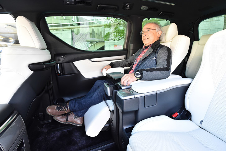 エグゼクティブラウンジシートでくつろぐ筆者。格納式のテーブルやスマートフォンホルダー、ファイルホルダーなど、執務を行うための装備も充実している。