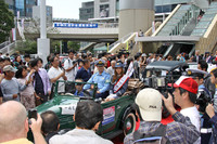 パレードに出発しようという一日署長を集まった人々が取り囲む。ほとんど見えないが、クルマは1938年「ダットサン17型フェートン」。