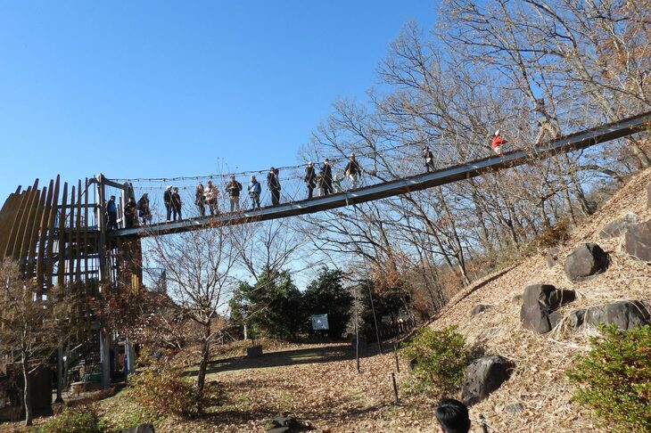 「冒険の塔」（写真左端）のつり橋を渡り、いよいよ本格的に里山散策へ。