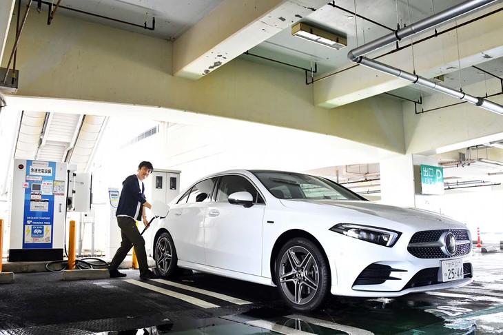 「A250eセダン」への給電を試みる筆者。同モデルは普通充電だけでなくCHAdeMO規格の急速充電にも対応している。