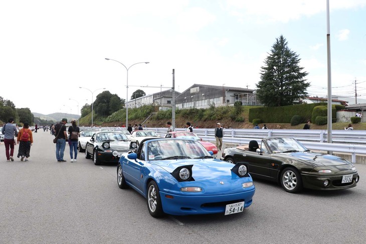 高速外周路の外側にある第一直線路にずらりと並べられたロードスター。多くのファンが、集結した歴代ロードスターを鑑賞して楽しんでいた。