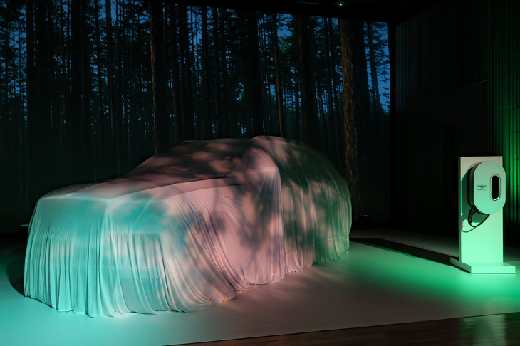 アンベールを待つ「ベントレー・ベンテイガ ハイブリッド」。右に見えるのは無償オプションとして用意されるベントレー純正のウォールボックス（家庭用充電ユニット）だ。