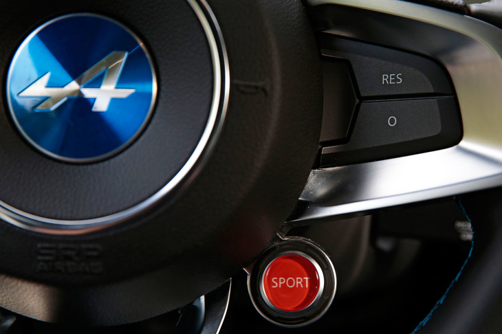ステアリングホイールのセンター右下には、走行モードのセレクター（写真の赤いボタン）が備わる。プッシュするたびにノーマルモードとスポーツモードが切り替わり、長押しでトラックモードに移行する。