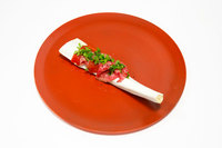 6皿目の「骨と肉」。水分を抜いたスイカとバーナーで軽くあぶった万葉牛ランプをラズベリービネガーやオリーブオイル、塩で味付けし、骨の上に盛り付けている。