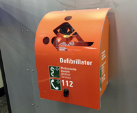 【写真6】フランクフルト・アム・マイン空港のAED。患者と救助する人を模した切り抜きは、無言のうちに用途を伝える。