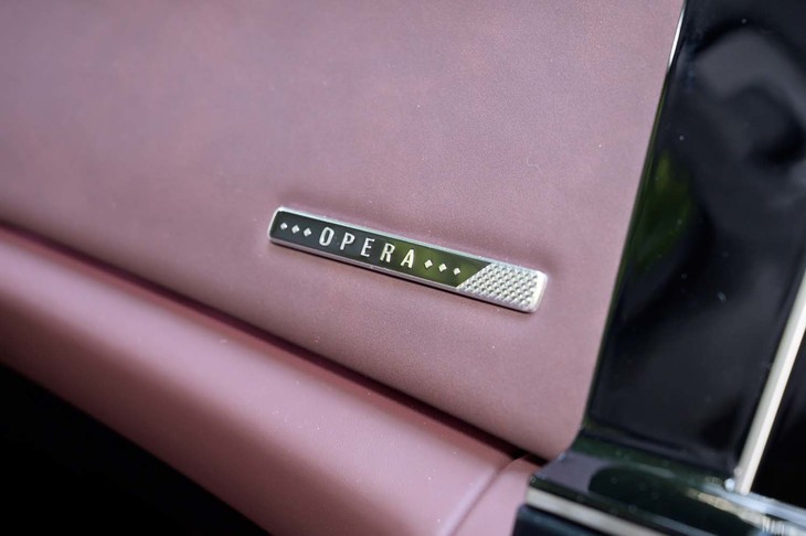 ダッシュボードに貼られた「OPERA」のバッジ。周囲のレザーを見るとむら染めであることがよく分かる。