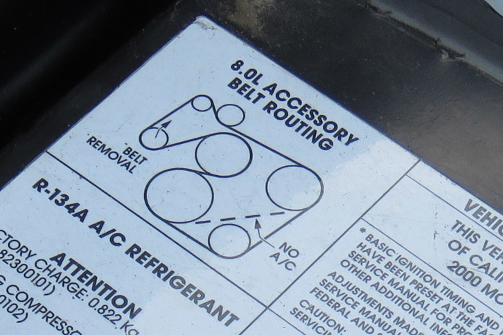 左フェンダーに、エンジンベルトの“ルート図”を発見。なにやら「NO A/C」って描いてあるけど、「バイパー」にエアコンレスの仕様なんてあったの？　夏場は地獄でしょうに……。
