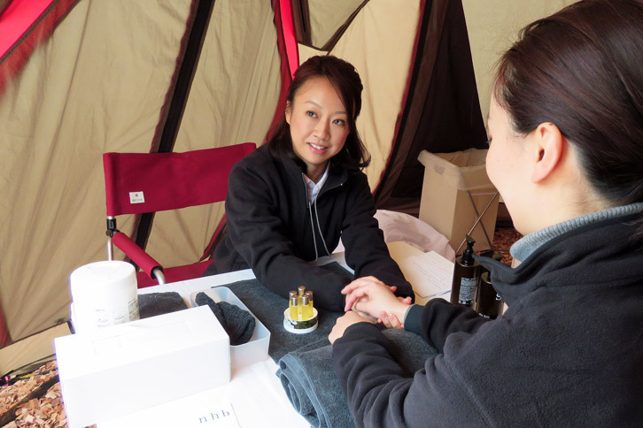 こちらは東京ミッドタウンなどに複数の店舗を持つ、uka（ウカ）のハンドリフレクソロジーのコーナー。テント内にはやさしいアロマの香りがただよっていた。