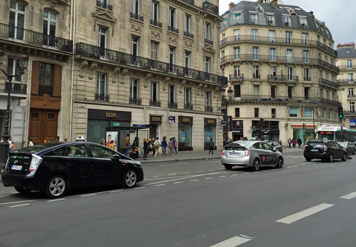 パリのオペラ座通りにて。写真に見られるタクシーは全て、日本車の「プリウス」または「プリウス＋」（日本名「プリウスα」）である。