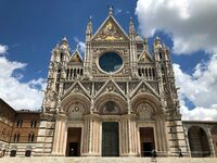 ニコラ・ピサーノの息子ジョヴァンニ・ピサーノによる《シエナ大聖堂のファサード》 1287-1296年。天に向かって限りなく伸長するかのような様相は、イタリアゴシック建築における絢爛（けんらん）の極致である。筆者撮影。