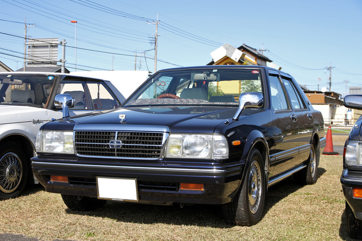 「日産グロリア セダン スーパーカスタムG」。型式名Y31と呼ばれる世代のセドリック／グロリアのセダンで、珍しい5段MT仕様。「エアコンやパワーウィンドウが標準装備された、MTが選択可能な最高級グレードがスーパーカスタムG。最初のオーナーはどうしてもMTでなくては、という年配の方だったそうです」とのこと。アルミホイールは「ブロアム」用。