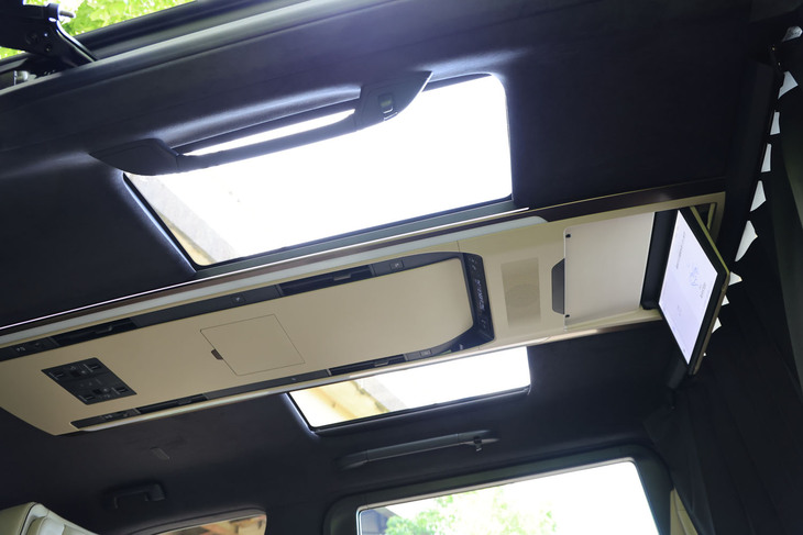 アルファードの「エグゼクティブラウンジ」と同じくルーフヘッドライニングはウルトラスエードで、電動シェード付きの左右独立式ムーンルーフも備わる。LEDルーフカラーイルミネーションやスライドドアパワーウィンドウ、パワースライドドアなどを操作できる天井の集中スイッチパネルが備わるのも同じだが、取り付け位置がシートレイアウトに連動して後方に移されている。