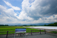 「貝野瀬ビューポイント」には、「四季折々に表情を変える“日本で最も美しい村”の景観をお楽しみください」の案内板が。左右に広がるこんにゃく畑の先に谷川岳を望む。