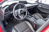 試乗車「マツダ3セダン」（北米仕様車）のインテリア。テスト用のため仕立てに未完成なところもあるものの、ゆるやかなラインが交差する、“囲まれ感”のあるデザインが見てとれる。