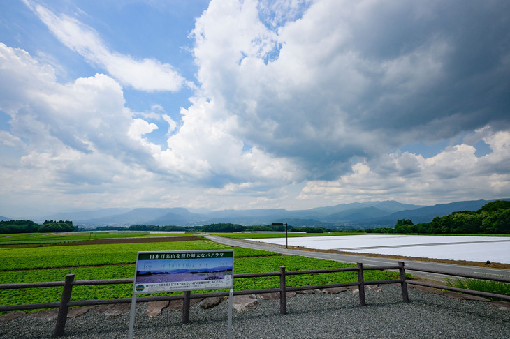 「貝野瀬ビューポイント」には、「四季折々に表情を変える“日本で最も美しい村”の景観をお楽しみください」の案内板が。左右に広がるこんにゃく畑の先に谷川岳を望む。