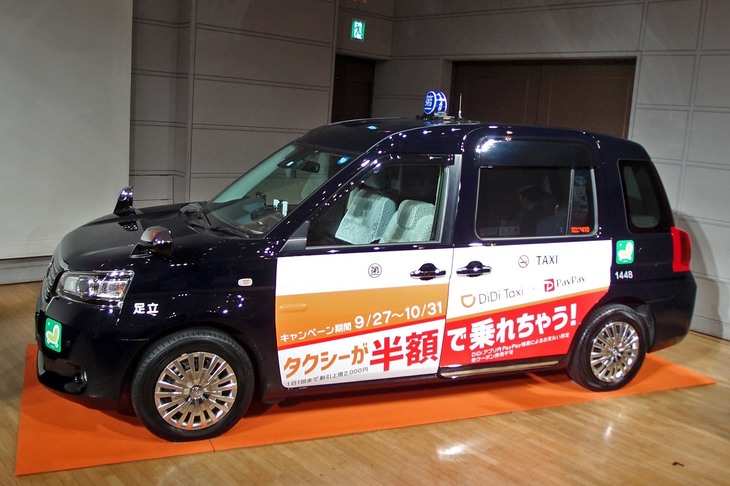 DiDiの配車サービスに対応するタクシーのイメージ。写真の展示車両には、割引キャンペーンのラッピング広告が添えられている。
