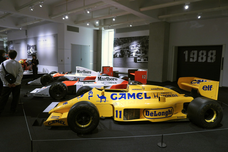 ホンダの第2期F1活動の展示エリア。写真手前から順に「ロータス ホンダ99T」（1987年）、「マクラーレン ホンダMP4/4」（1988年）、「マクラーレン ホンダMP4/6」（1991年）。皆さん、アイルトン・セナの搭乗機に目を奪われていたが……。