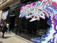 パリのシャンゼリゼ通りにて。プジョーの看板ショールーム「プジョーアヴェニュー」のガラスに、大胆なグラフィティが！