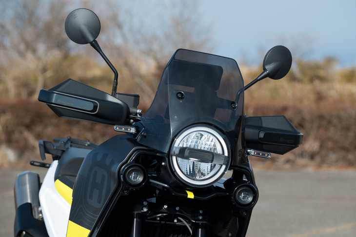 小柄ながらも高い防風性を発揮するウインドスクリーン。手を走行風から守るハンドルカバーとも相まって、ツーリング時の快適性は上々だ。