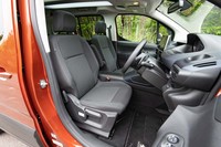 シート表皮はざっくりとしたグレーのファブリック。前席には収納可能なセンターアームレストが備わる。