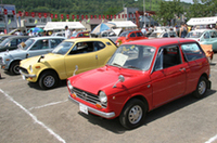 【写真上】抜けるような晴天のもとで行われた第19回北海道クラシックカー・フェスティバル。会場は赤平市コミュニティー広場。会場脇の広場で、前日からキャンプする参加者の姿も少なくない。（写真＝studio M's）【写真下】軽自動車が並ぶ一画で見つけたごく初期の「N360」。丁寧に使い込まれてきた年輪がとても好ましかった。