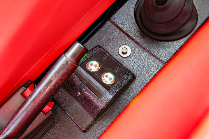 フロアに追加された2個のスイッチ。「リバースモード」（モーター逆回転）はボタンを押したらオンになるのに対し、「スポーツモード」は押したらオフになる。不思議である。