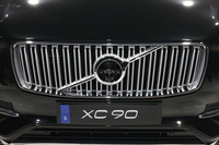 新型「XC90」のフロントグリル。アイアンマークが新しくなり、右上の矢印がグリルを斜めに横切るラインと重なった（従来はずれていた）。
    