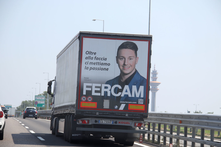 （写真G）。運送会社フェルカムのトラック。一社員の顔とともに「顔以上に情熱を載せています」の文字が。