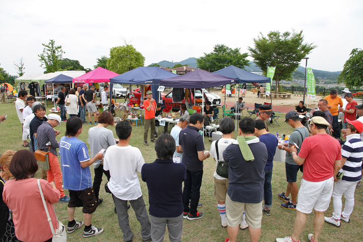 会場で実施されたビンゴ大会のシーン。イベントの参加費は無料だが、その代わりに参加者はビンゴゲームの景品を1点ずつ持ち寄るというのが決まりなのだ。後方に並ぶテントはスワップミート。