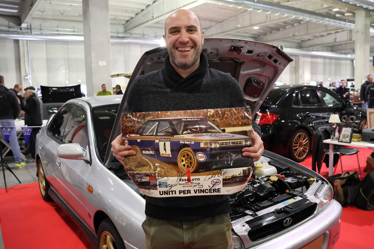 ジュゼッペ・ザンベッリ-レインさん。宝物であるコリン・マクレーをはじめ、スバルのラリードライバーのサインを集めたポスターとともに。