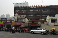 上海・中山公園付近で。高層アパートやオフィスが立ち並ぶそばに、古い商店や建物が残る。