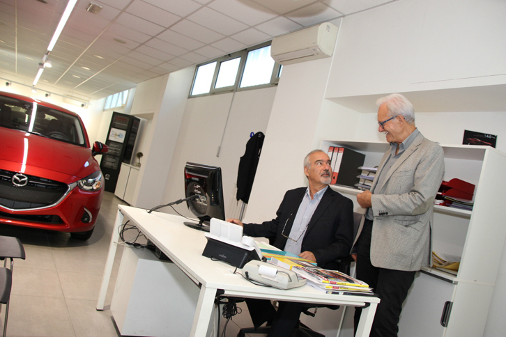 マツダ車の展示コーナーで。ルノーの販売店から転身したジャンニ・バンディーニ氏（左）とエンツォ氏。