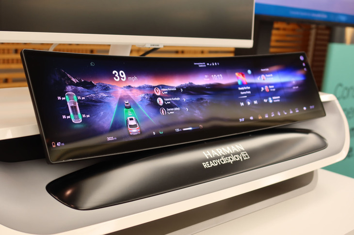 1946年のJBL創設からスタートしたハーマン。その後、harman/kardonブランドを加えるなどして1984年にカーオーディオのOEM供給を開始。現在の取り扱い分野はインテリジェントコックピットにもおよび、カーオーディオとともにシェア1位となっている。2025年5月6日には、デノンやBowers & Wilkinsといったブランドの取り込み（買収）も発表するなど、事業は拡大傾向にある。写真はオートモーティブ分野の製品のひとつであるカーブドディスプレイ。
	 