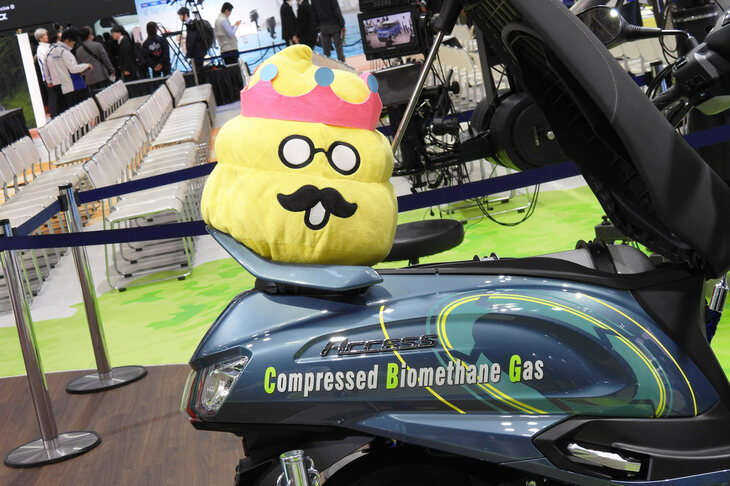 「スズキ・アクセス（CNG／CBG仕様）」と人気キャラクターの「うんこ先生」。