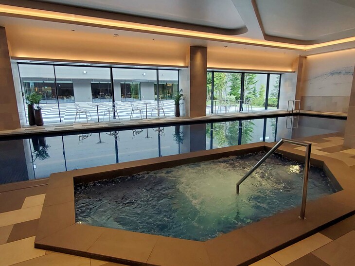 富士スピードウェイホテルには、癒やしの施設を集めたウェルネス棟も併設されている。こちらは20mプールとジェットバス。白と黒のフロアが特徴的な屋外スペースは、チェッカードフラッグを模したものだという。