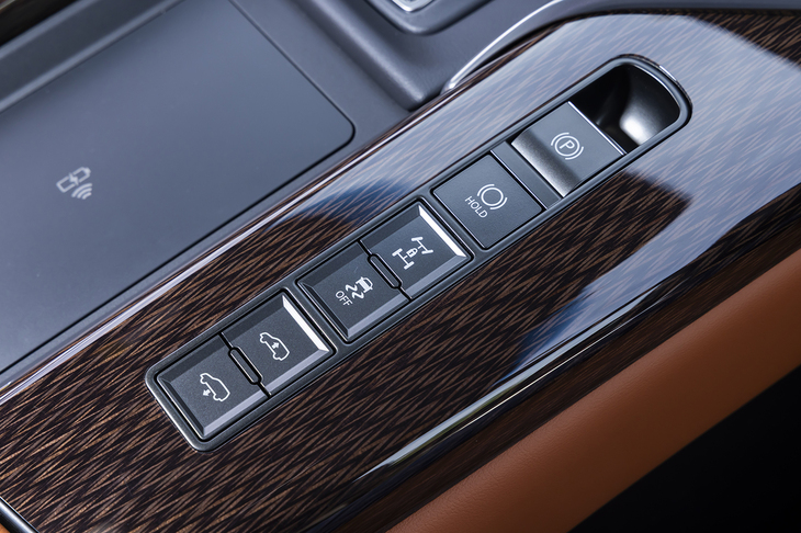 センターコンソールにはセンターデフロックや車高調整のスイッチが並ぶ。その周囲が「鷹羽」のオーナメントパネルで、職人が丁寧に寄木を施し、3度の切削を経て鷹の羽根を表現している。