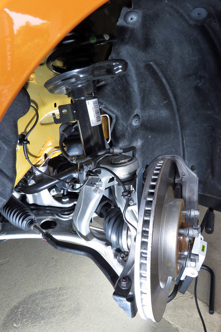 フロントサスペンションを斜め後方の側から見たところ。ストラットより外側にナックルが装着されているのが分かる。