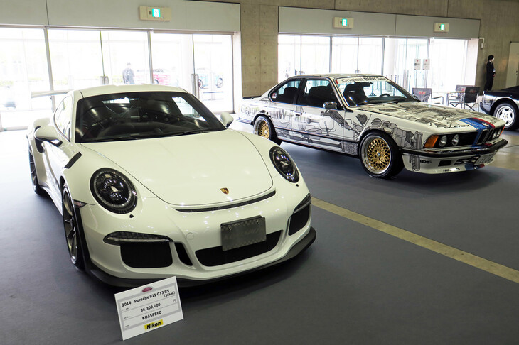 KOA SPEEDの出展した「ポルシェ911 GT3 RS」（写真向かって左）と、シルキーシックスの「BMW 635CSi」（同右）。
