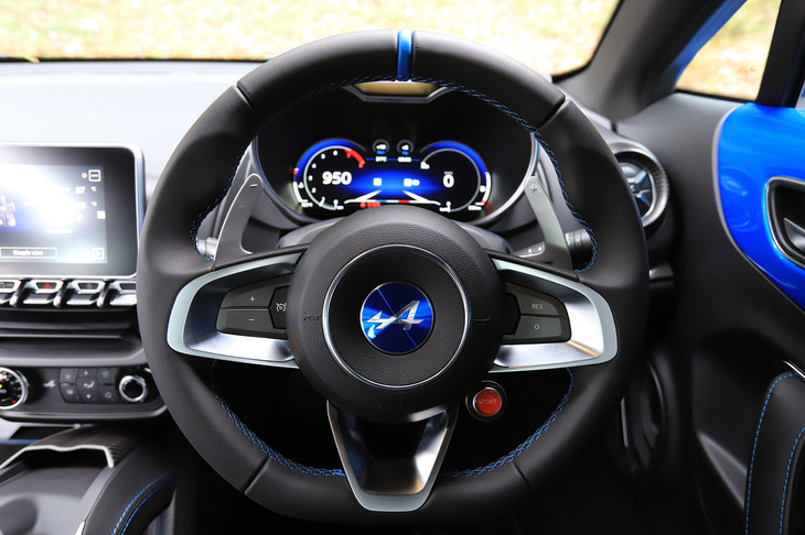 ステアリングホイールは、リムの下部がフラットな形状。センター右下には、走行モードのセレクター（赤いボタン）がレイアウトされる。